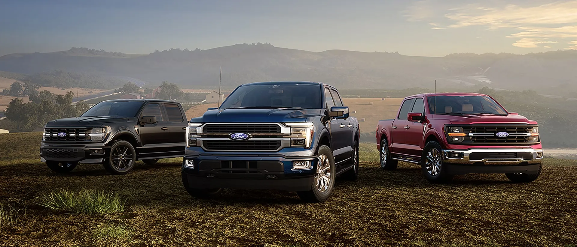 Trois Ford F-150 2026 de différentes versions stationnés côte à côte dans un paysage ouvert.