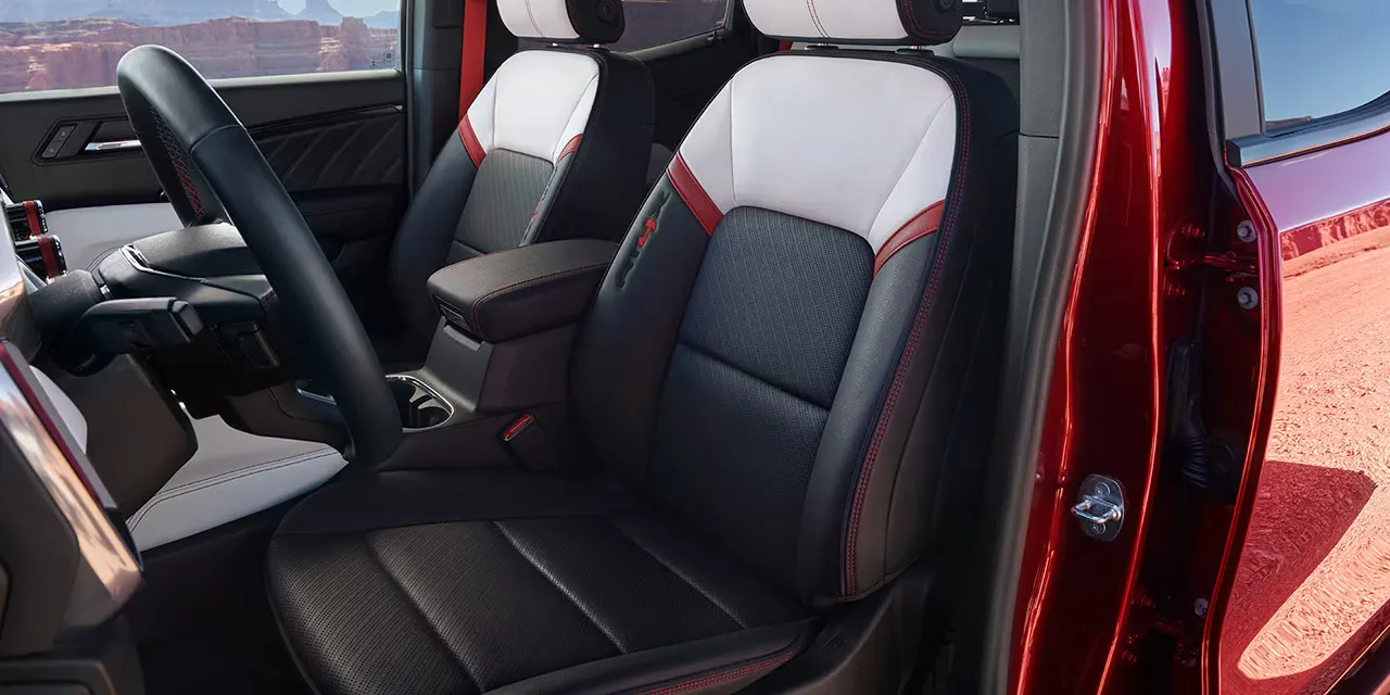 Sièges avant du GMC Canyon 2026 avec sellerie contrastée dans l’habitacle.