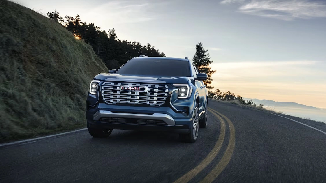 GMC Terrain 2026 bleu sur une route de montagne. Un VUS compact 2026 moderne et technologique.