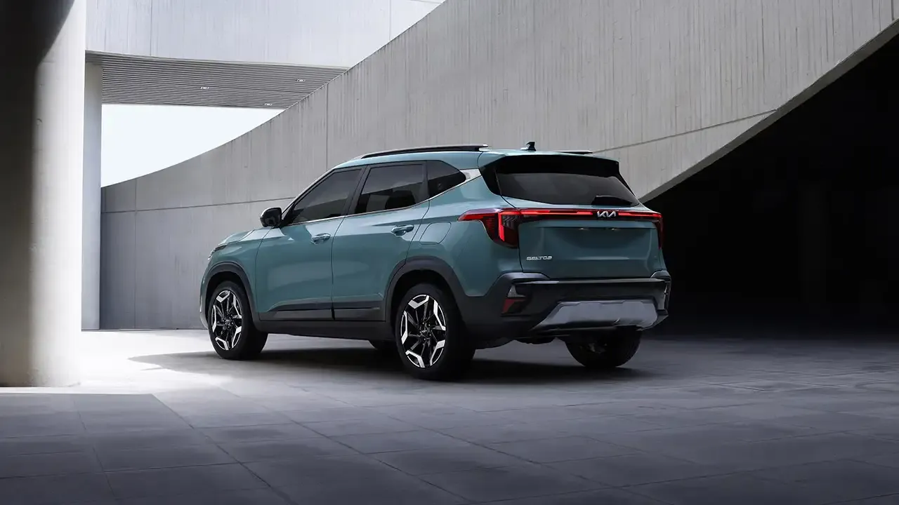 Kia Seltos 2026 bleu vu de l’arrière devant une architecture moderne.