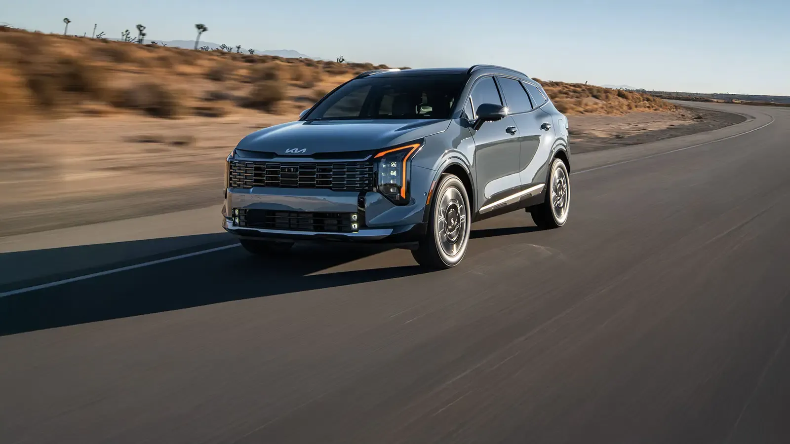 Kia Sportage 2026 sur une route en milieu désertique. Un VUS compact 2026 offert aussi en version hybride rechargeable.