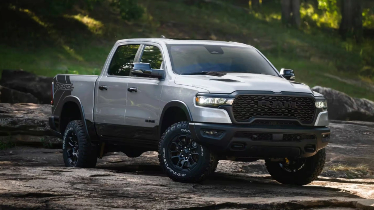 Ram 1500 2026 gris stationné sur un terrain rocheux en forêt.