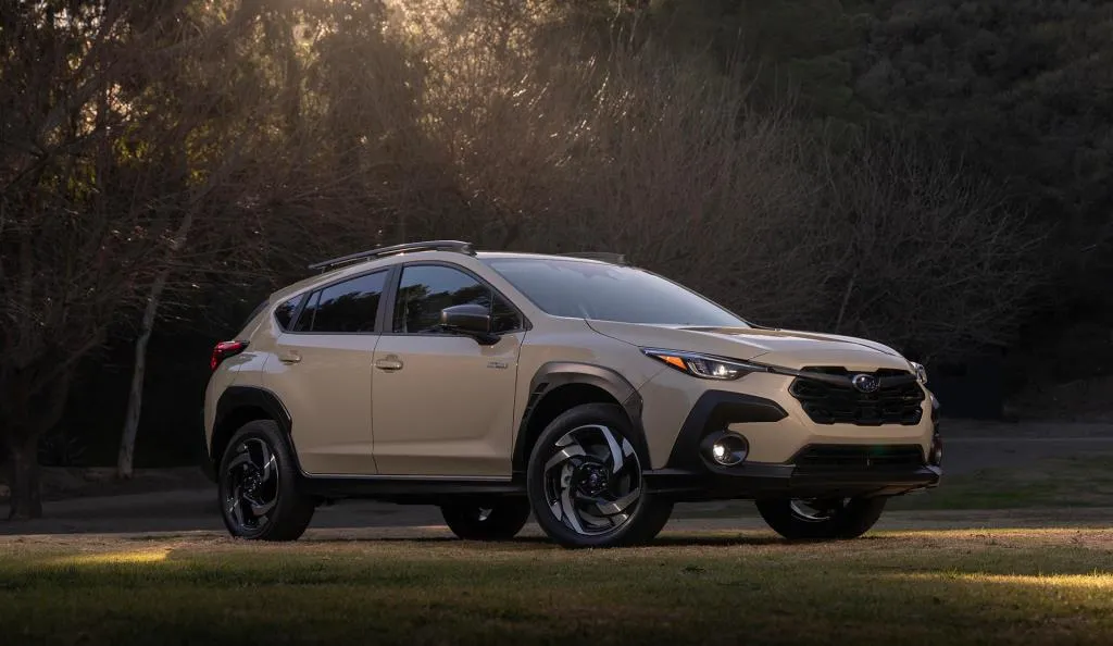 Subaru Crosstrek 2026 beige vu de trois quarts dans un environnement boisé.