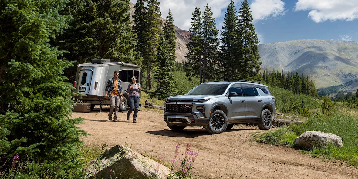 Chevrolet Traverse 2026 avec remorque en road trip dans un paysage montagneux.