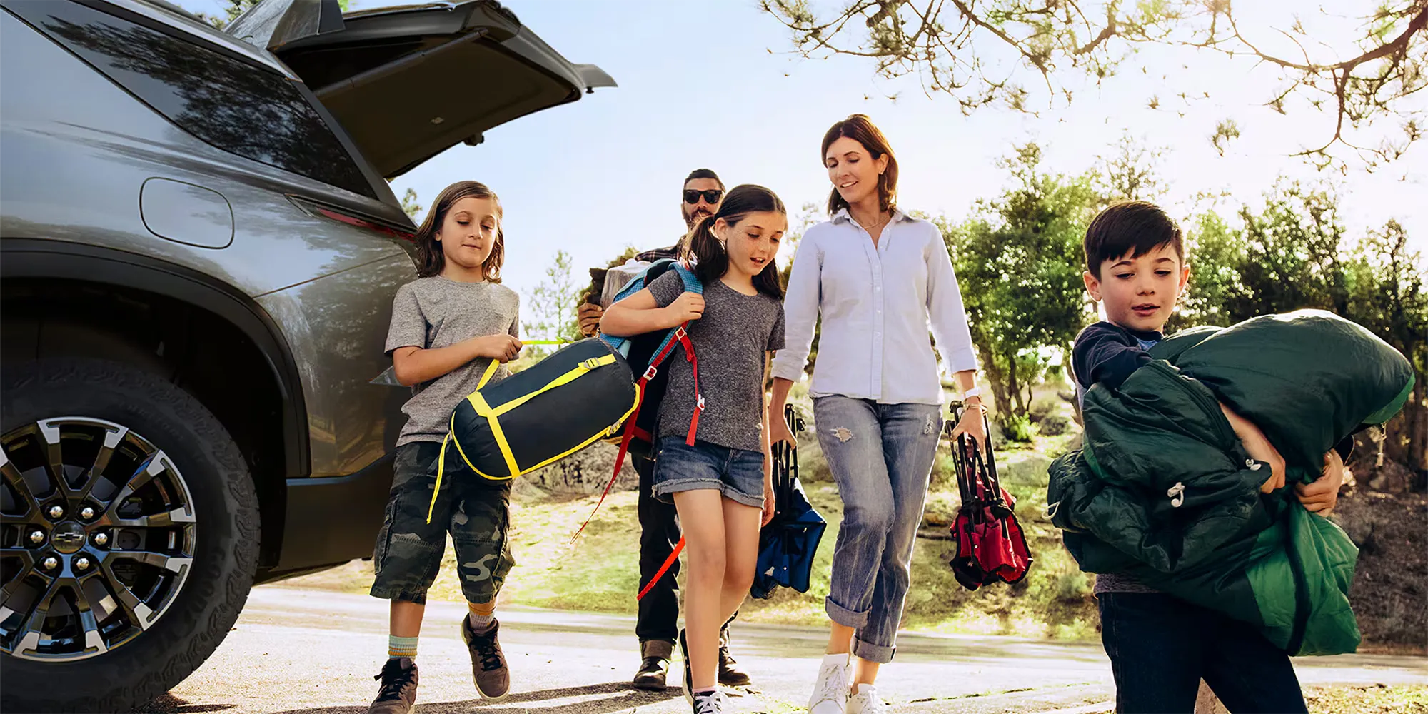 Famille préparant ses bagages près d’un Chevrolet Traverse 2026 pour un voyage avec un VUS 7 places.