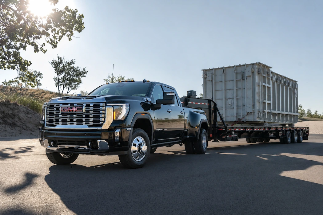 GMC Sierra 3500 HD 2026 remorquant une lourde charge commerciale avec roues arrière jumelées.
