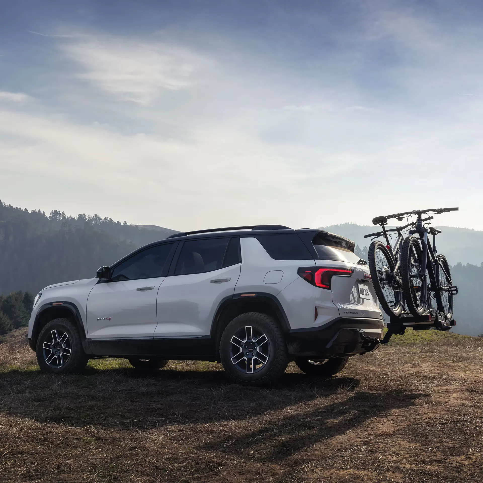 GMC Terrain 2027 blanc équipé d’un porte-vélos arrière pour les sorties en plein air.